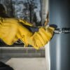 Construction Worker Attaching Home Gutters to the Building Wall